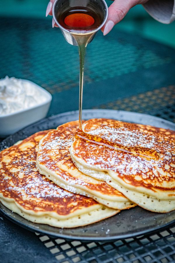 Pouring syrup on pancackes