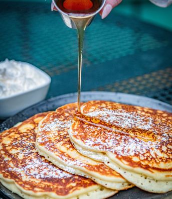 Pouring syrup on pancackes